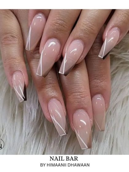 A very modern and graphic design on long coffin nails, using thin white lines over a nude base with sharp brown accents.