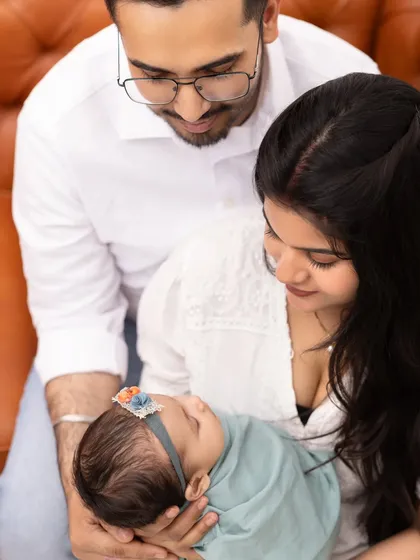 An overhead view of parents gazing lovingly at their newborn baby. This perspective creates a feeling of warmth, protection, and deep connection.