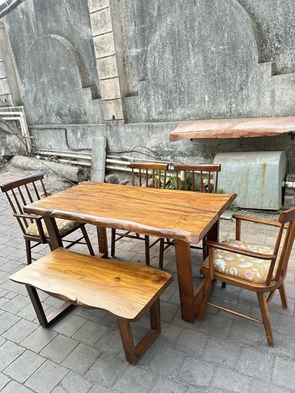 A full view of the rustic dining table, bench, and chairs.