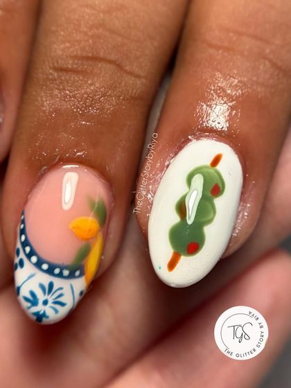 A close-up of a fun, food-themed nail set, showing a hand-painted skewer of olives.