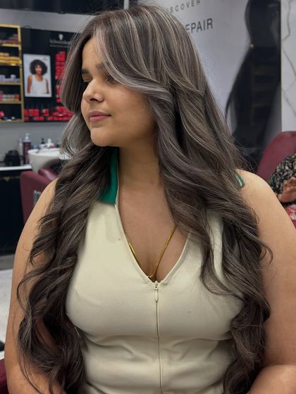 A side profile of the fresh ash hair color, showing how the cool tones and waves create a modern, chic look.