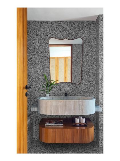 This bathroom showcases a custom multileveled, capsule-shaped floating wash basin in marble. The design plays with shape and material, creating a unique and functional centerpiece.