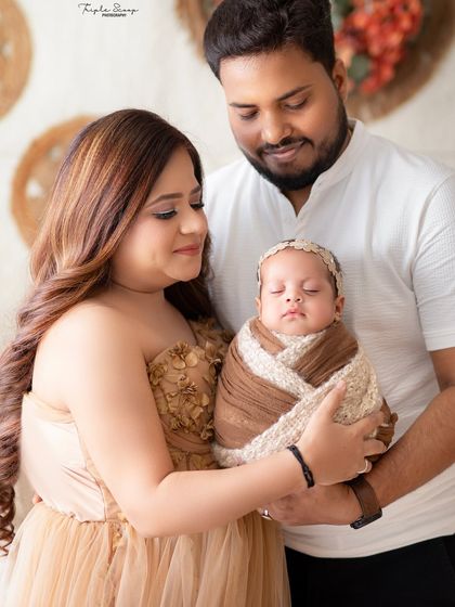 New parents lovingly gazing at their sleeping baby. My studio provides a calm and comfortable environment for these precious first photos.
