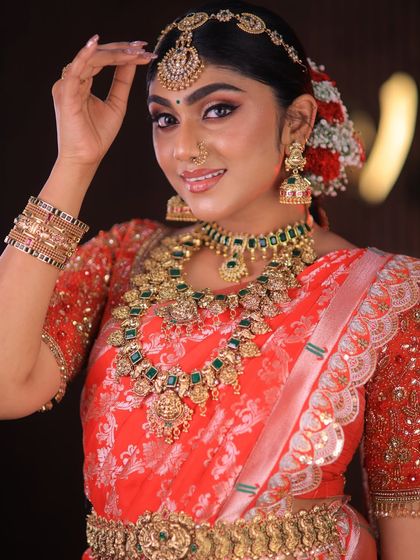 This stunning red floral saree is styled for a high-fashion bridal shoot. The drape is immaculate, designed to look dramatic and beautiful on camera.