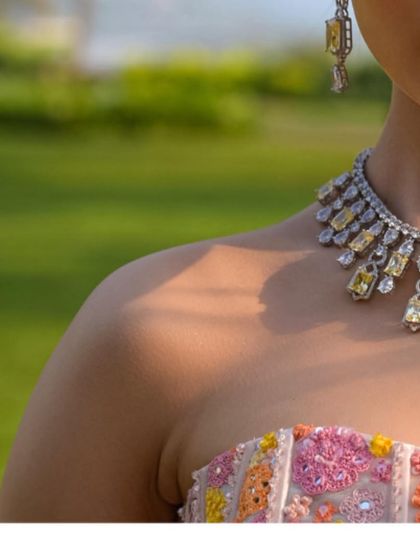 A detailed shot of the yellow diamond necklace against the bride's skin. The warmth of the stones is perfect for a sun-kissed, outdoor event.