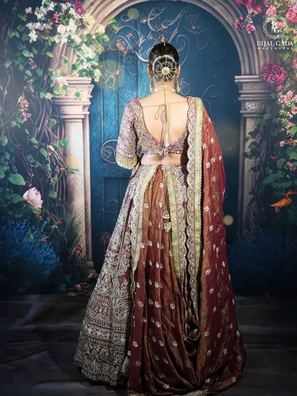 The back view of this bridal ensemble showcases an elegant hair bun and the beautiful draping of the dupatta. Every detail, from the hairstyle to the outfit, is carefully curated for a complete look.