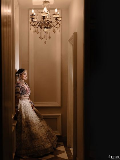 A full-length portrait of the bride in a beautifully lit corridor, showcasing her elegant poise.