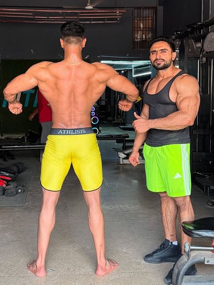 Checking my client's back development. A wide, detailed back is crucial for a winning physique.