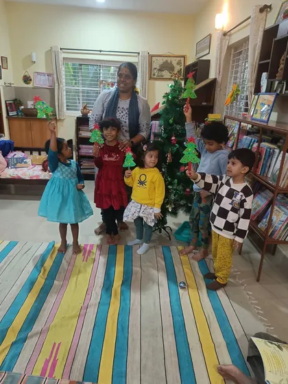 Holiday crafting is always a favorite. Here, children proudly hold up the Christmas tree crafts they made after our special festive story session.