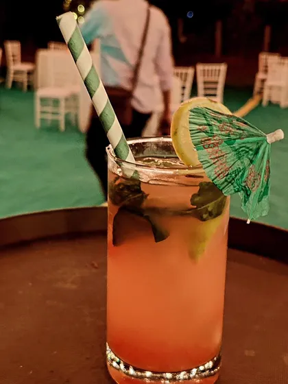 A refreshing pink mocktail served in a highball glass with a paper straw and a mini umbrella. We offer a full range of delicious non-alcoholic options so all guests can enjoy a special drink.