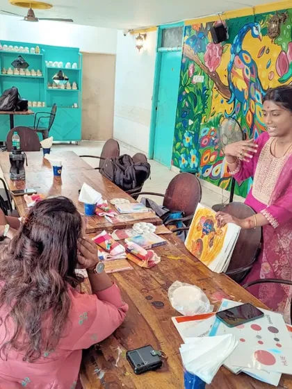 The instructor, Padma Srinivasan, shares insights and techniques with participants during the Awakening Shakti watercolour workshop, surrounded by colorful murals.