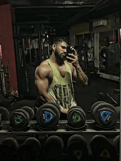 Another angle of the tricep pose. The lighting in the gym helps to highlight the muscle definition.