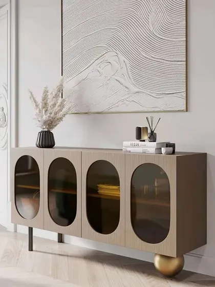 Another view of the Plisse cabinet, highlighting its unique spherical leg and the elegant oval glass windows.
