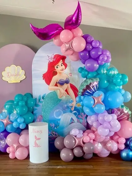 An "Under the Sea" birthday party with a Little Mermaid theme, showcasing a colorful balloon garland that mimics ocean waves and bubbles.
