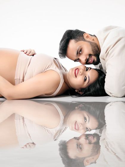 A sweet, reflective moment captured on our mirrored floor. This creative shot shows the couple lying down, creating a beautiful reflection that adds an artistic touch to this minimalist portrait.