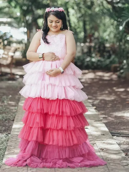 This mother-to-be is wearing our popular tri-color ombre gown with pink and red layers, a playful and eye-catching choice for an outdoor shoot.