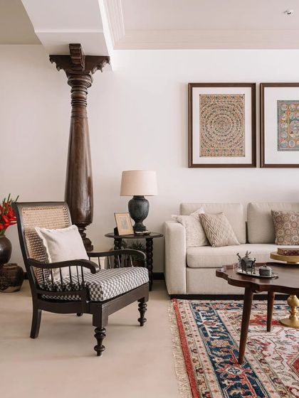 The living room is a blend of old and new, with a reclaimed antique pillar, traditional artwork, and comfortable modern seating.