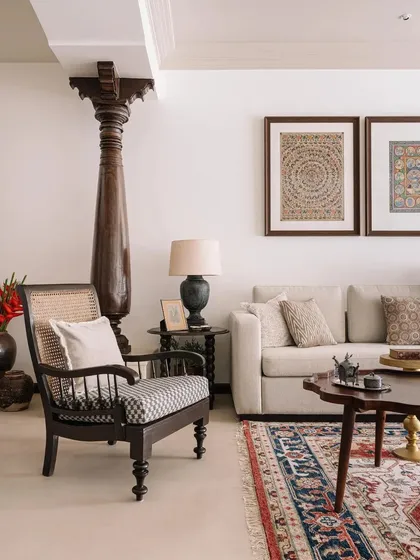 The living room is a blend of old and new, with a reclaimed antique pillar, traditional artwork, and comfortable modern seating.