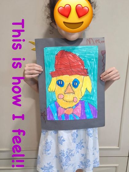 This is how it feels to create something you are proud of. This student's joy is evident as she shows off her finished scarecrow artwork.
