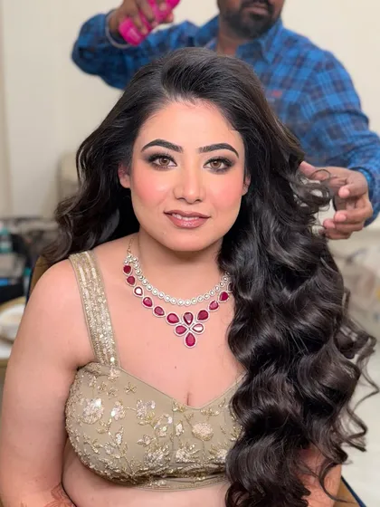 Bhoomika getting her hair done for her engagement. The makeup is already looking glamorous with a classic smokey eye.