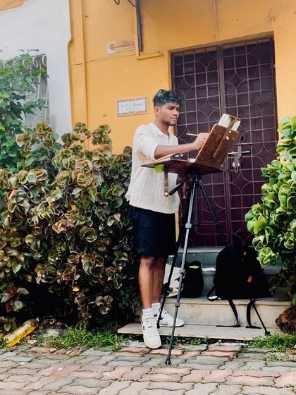 A photo of me painting on location in Fontainhas. The vibrant buildings and lush greenery are incredibly inspiring.