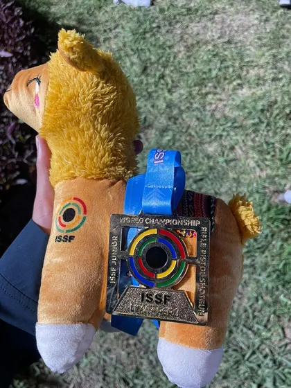 The official mascot from the ISSF Junior World Championship in Lima, Peru, adorned with a gold medal. A cherished memento from a victorious international competition.