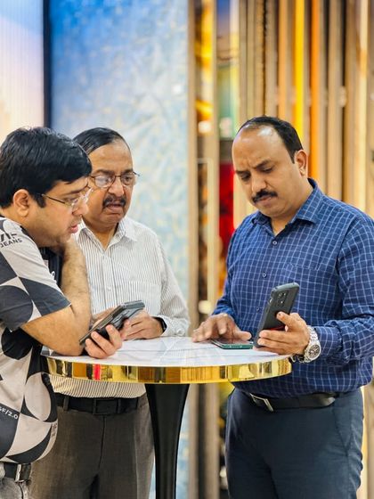 A group of clients looking at design options on a phone. Digital previews are a key part of our consultation process.