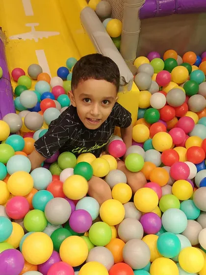 A bright smile from our vibrant ball pit. We keep our play areas clean and safe for your peace of mind.