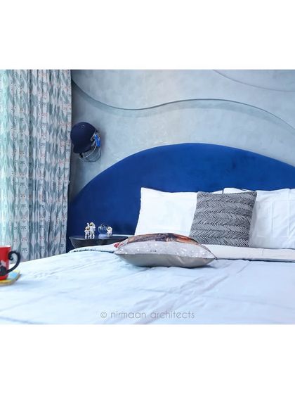 A close-up of the custom-designed headboard in the teenager's room. The wavy, layered design in a bold blue color makes a strong style statement.