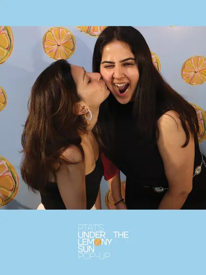 A playful and affectionate moment between friends at the PTAT pop-up. Our booth captures the warmth and connection between your event's attendees.