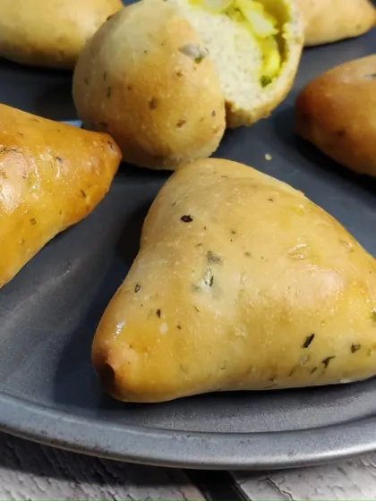 A tray of freshly baked aloo buns and other stuffed breads.