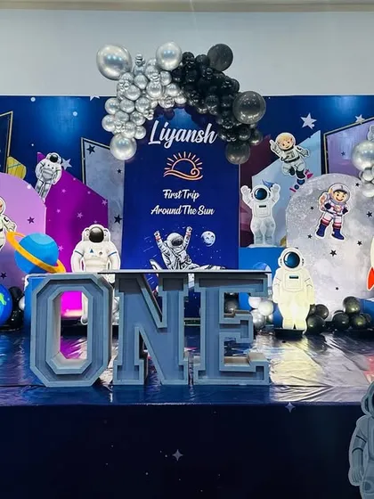 An out-of-this-world space theme for a first birthday party. I designed this entire stage with astronaut cutouts, rocket ships, planet props, and a floor that looks like the galaxy.