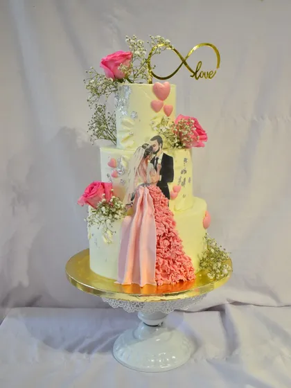 A close-up of the custom couple figurine and ruffled dress detail on a three-tier wedding cake. I love adding these personalized touches that make each cake unique to the couple's story.