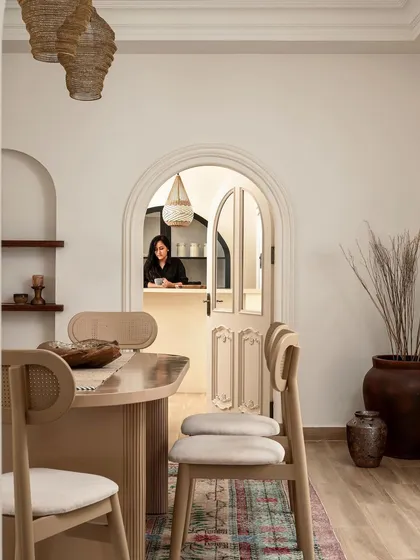 The dining room at Ivy Lane Villa, designed for family gatherings. The light oak dining set and woven pendant lights introduce a touch of modern Scandinavian design, which contrasts beautifully with the home's colonial architecture.