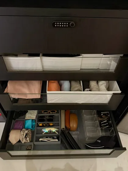 A detailed view of accessory drawers in a man's closet. We use clear acrylic and felt-lined dividers to create a designated spot for sunglasses, belts, watches, and more.