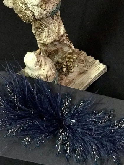 For a sophisticated and elegant look, this navy blue feather accessory is a stunning choice.