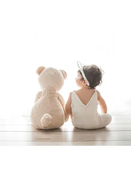 A baby and their first best friend. This simple, light-filled portrait captures a sweet, candid moment, showing a glimpse of the beautiful journey of childhood that is just beginning.
