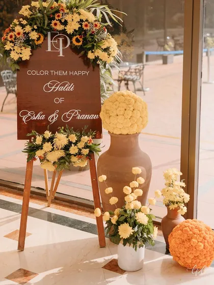 The welcome easel surrounded by terracotta pots and spheres of marigolds.