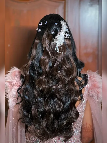 A view of the bride's long, flowing curls, adorned with delicate butterfly accessories.