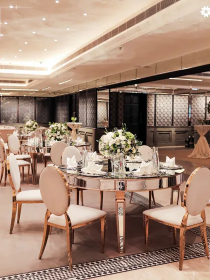 The elegant indoor dining space at Araya Bagh, New Delhi. The classic decor and mirrored accents provide a sophisticated backdrop for corporate events and weddings.
