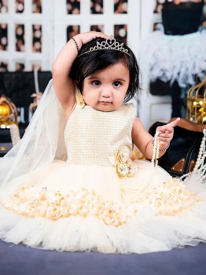Adjusting her tiara, this little princess is ready for her close-up in a glamorous, fashion-inspired setting.