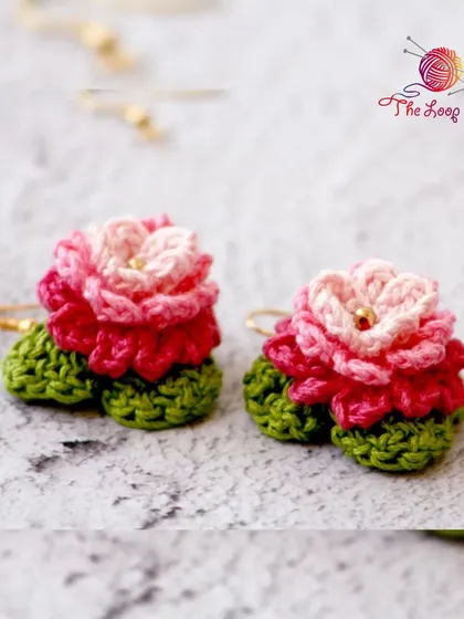 These beautiful crochet flower earrings feature multiple layers of pink petals and a golden hook.