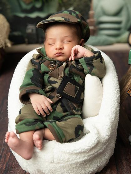 This angle captures the baby's sweet sleeping face as they rest in the miniature armchair.