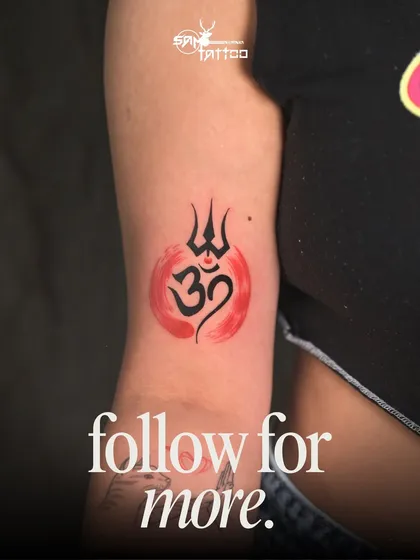 A vibrant Trishul and Om tattoo with a watercolor background, one of the many pieces we've created for our loyal client, Aanchal.