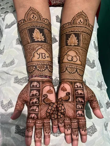 A unique design featuring peacocks and baby elephants on the palms, with the couple's initials and wedding rings incorporated on the arms.