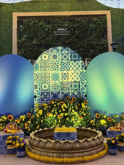 A detailed shot of the Haldi ceremony setup, with the 'urli' ready for the rituals, surrounded by fresh flowers.