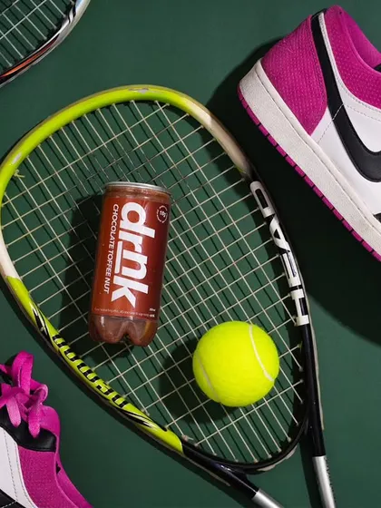 To give this chocolate drink an energetic and sporty vibe, I styled it with tennis rackets and sneakers. This conceptual approach connects the beverage to an active lifestyle, telling a story beyond just the flavor.
