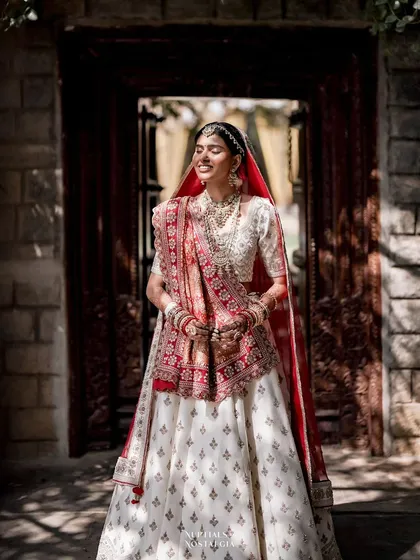 A bride, bathed in the sunlight filtering through a doorway, her expression one of pure happiness.
