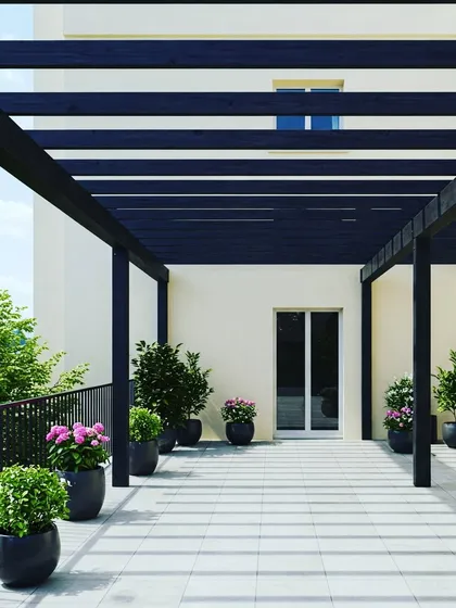 A long, black metal pergola creating a shaded walkway or gallery space on a large terrace. This design is perfect for connecting different parts of a building or for lining a rooftop with shaded seating.
