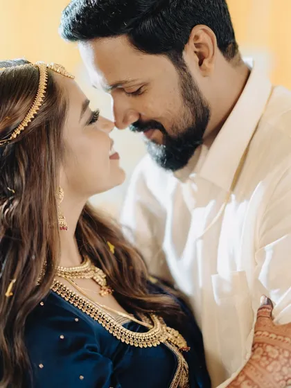 An intimate couple's portrait filled with love and warmth. The bride's makeup looks soft and beautiful even in this close-up, candid moment, showcasing a natural and comfortable finish.